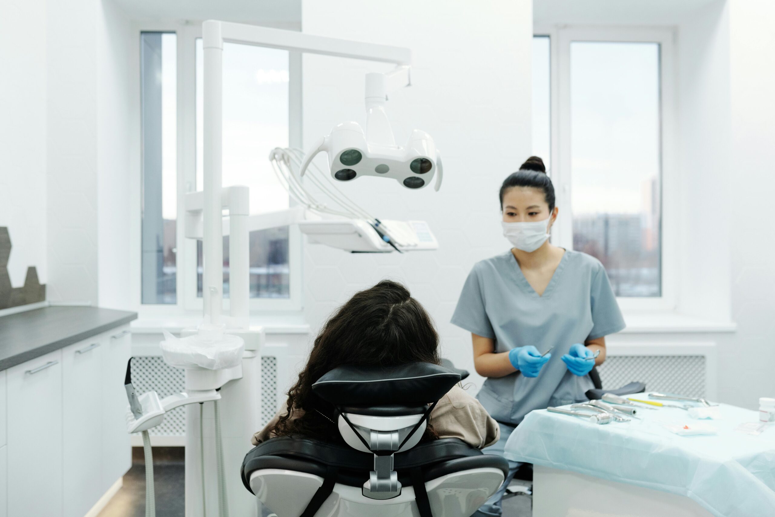 Dentist with a patient in a modern dental clinic performing an examination.